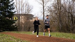 two people running on a dirt trail