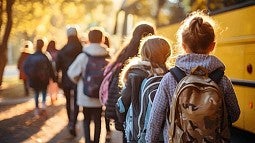 kids standing next to a school bus